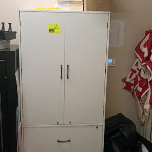 Storage cabinet featuring a two-door upper compartment and two lower drawers. Finished in white. Includes various office and retail supplies as shown,