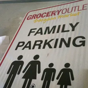 Lot of Grocery Outlet metal parking signs. Includes a reflective 'Family Parking' sign with family pictogram and a 'Customer Parking Only' sign featur