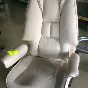 Flux computer chair. Features cream-colored upholstery with quilted accents, padded high-back design, and integrated padded armrests. Mounted on a chr