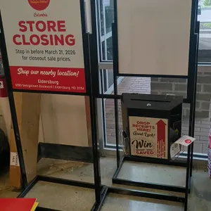Metal floor-standing sign holder. Features a black metal frame designed to accommodate 22"W x 28"H sign inserts. Mounted on a flat rectangular steel b