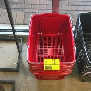 Poly shopping basket. Features red plastic construction, dual wire carrying handles with plastic grips, and a perforated grid design. Stackable for co