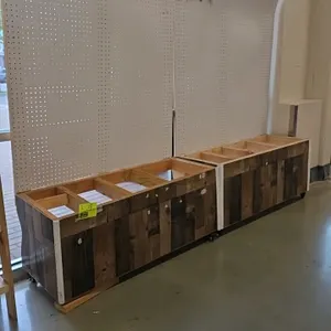 Wood merchandiser with pegboard backing. Features a rustic wood-look paneled lower cabinet with an open-top frame and a white pegboard back panel with