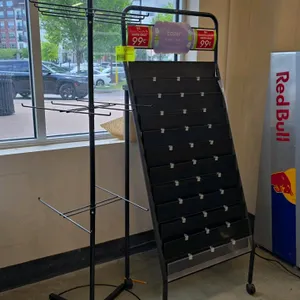 Retail display rack lot. Includes (1) portable tiered greeting card display stand with eleven shelves, mounted on casters, and (1) black spinning meta