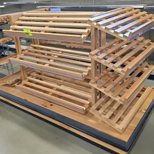 Portable wood multi-tier merchandiser display rack. Features double-sided island design with slatted wood shelves on metal upright support brackets. M