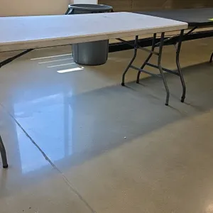Poly folding table lot. Includes (1) white 5' poly folding table and (1) black 6' poly folding table. Both feature molded plastic tops and folding met
