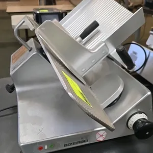 Bizerba SE 12 US manual gravity feed deli slicer. Features 13" blade, adjustable slice thickness, and anodized aluminum construction. S/N: 10196788. E