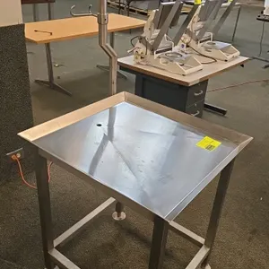 Stainless steel equipment stand with bagging stand. Features a 27"x29" pitched platform with a center drain. Includes a post-mounted stainless steel b