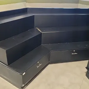 Laminate 3-tier plant and flower display. Features an angled corner configuration, stepped 3-tier design, and 2 lower storage drawers with metal T-bar