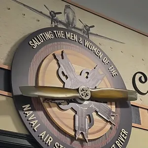 A Custom "Naval Air Station - Patuxent River" Tribute Sign. (Unknown, Modern) A large circular display sign reading "Saluting the Men & Women of the N