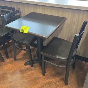 Table and chair set. Includes (1) table featuring a 24" x 30" dark laminate top mounted on a black metal pedestal X-base, and (2) matching ladder-back