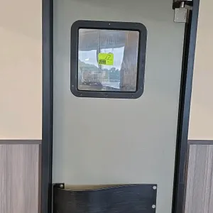 Poly swing door. Features a durable polymer panel with an integrated square viewing window, double-acting gravity hinges, and curved black lower impac