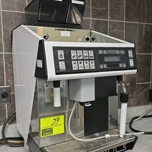 UNIC Tango super-automatic espresso machine. Features integrated dual coffee grinders with hoppers, milk steam wand, and dedicated hot water dispenser