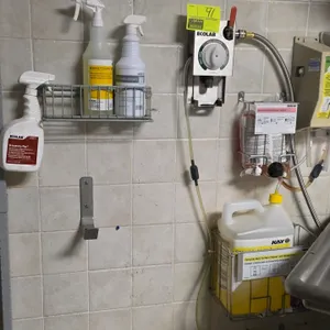 Ecolab wash and rinse chemical dispensing system. Wall-mounted proportioner unit with selector dial. Includes assorted wire chemical storage baskets, 