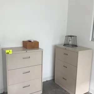 Metal 3-drawer lateral filing cabinet. Features three drawers with integrated pull handles and a beige finish. 30"W. Contents and items on top not inc