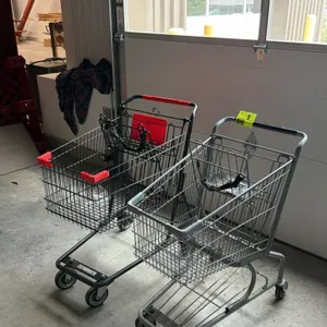 Assorted metal shopping carts. Includes one black powder-coated wire cart with red plastic trim and child seat, and one grey zinc-plated wire cart wit