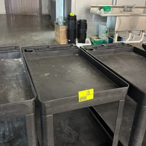 Unbranded 2-tier poly utility cart. Features molded-in storage compartments and handle. 3'L. Mounted on casters.