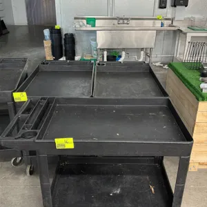 Poly 2-tier utility service cart. Features black plastic construction, deep tub shelves, and a molded-in handle with integrated tool compartments and 