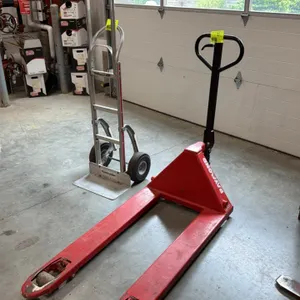 Raymond manual hydraulic pallet jack. Features red steel frame construction, loop handle with integrated control lever, and dual entry rollers. Hand t