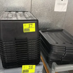 Stack of black poly meat lugs with lids. Features durable polyethylene plastic construction, integrated handles, and a nestable design for easy storag
