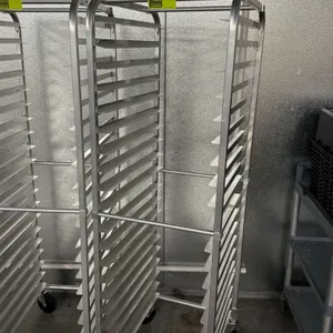 Aluminum full-size front-load sheet pan rack. Features 20-tier channel slides designed for standard bun pans. Mounted on swivel casters. Neighboring r