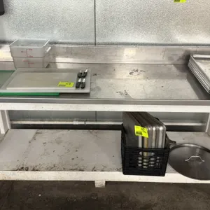 Stainless steel top work table. Features a stainless steel work surface with a backsplash, mounted on a white painted wooden frame with a lower utilit