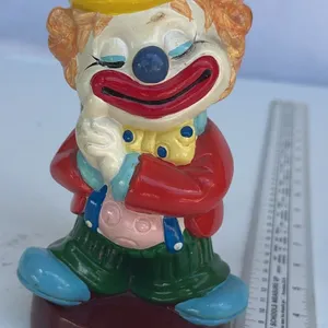 The clown bank in the red jacket and yellow hat is a figurine of Emmett Kelly Jr.