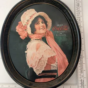 Vintage Coca-Cola metal tray features the 1914 "Betty Girl" artwork on an oval design
