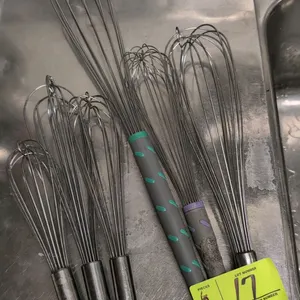 Assorted stainless steel whisks. Includes four whisks with stainless steel handles and two whisks with textured composite handles of various lengths a