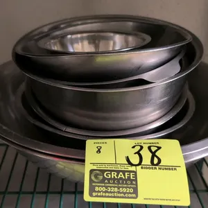 Assorted stainless steel mixing bowls. Set includes 8 bowls in varying sizes and styles. Features durable construction with rolled or flat rims. Ideal