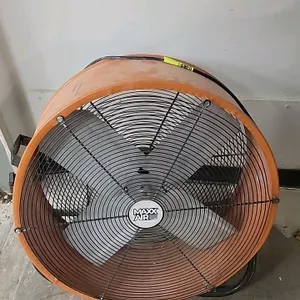 Maxx Air 24" industrial floor fan. Features a 4-blade fan design, tiltable orange steel drum housing, front and rear wire grilles, and integrated carr