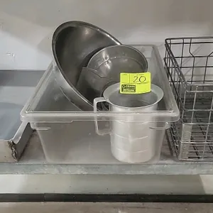 Assorted bakery wares. Includes (1) metal wire crate, (1) clear plastic storage tub, (2) stainless steel mixing bowls, (1) aluminum measuring pitcher,