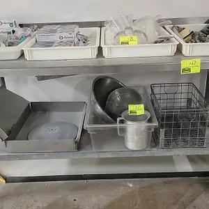 Portable stainless steel work table. Features a stainless steel top with a rear backsplash and a galvanized steel undershelf. Mounted on swivel caster