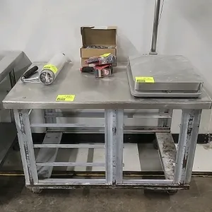 Portable stainless steel work table featuring a stainless steel top and an integrated lower tray slide rack system. Mounted on casters. Dimensions: 48