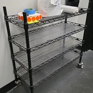 Unbranded 4-tier mobile wire shelving unit. Features black wire construction and plastic shelf liners. Dimensions: 36"x14"x37.5". Mounted on casters. 