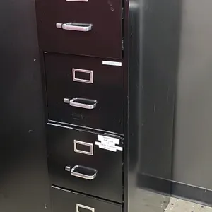 Metal 4-drawer vertical filing cabinet. Features black finish, pull handles, and integrated label holders. Built-in lock cylinder on top drawer (keys 