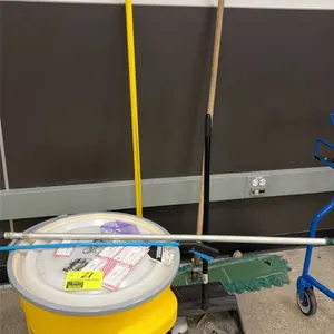 Maintenance equipment lot. Includes a yellow polyethylene salvage drum with lid, a black plastic lobby dustpan, a green dust mop with wooden handle, a