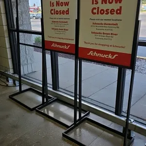 Metal sign stand. Features black metal frame construction with a flat square base. Designed to hold rigid sign inserts.
