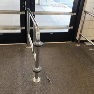 Floor-mounted chrome guide rails. Features heavy-duty chrome construction with integrated black cart bumpers. Designed for pedestrian traffic control 