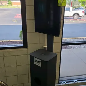 2018 Samsung DC32E color display unit. Features portrait orientation mounting on a black metal kiosk stand with an integrated Purell Wipes dispenser b