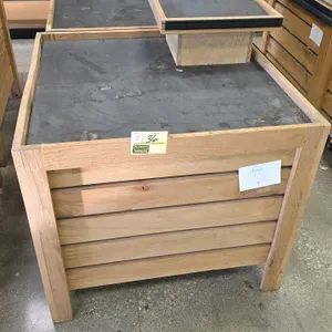 Bradley wood produce display. Features slatted wood side paneling, a recessed top deck with a protective black rubber liner, and solid wood constructi