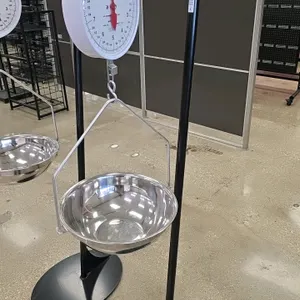 Detecto MCS-20F hanging produce scale. Features a 20 lb x 1 oz capacity dial with a stainless steel pan and hanger. Mounted on a National Cart Co. bla