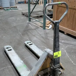 Manual pallet jack. Features steel construction, dual steer wheels, and tandem load rollers. Background items not included.