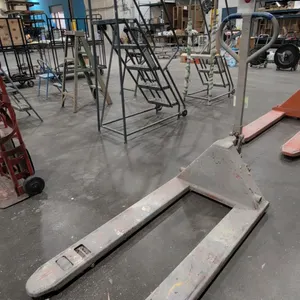 Manual pallet jack. Features steel frame construction, loop-style control handle with release lever, and integrated hydraulic pump lift mechanism. Equ