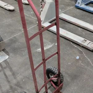 Metal hand truck. Features a red painted steel tubular frame, continuous loop handle, and a fixed nose plate. Mounted on two pneumatic tires.