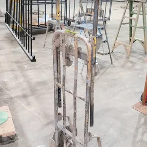 Metal hand truck with dolly attachment. Features a tubular steel frame, two solid rubber main wheels, and a dual swivel caster attachment with a sprin