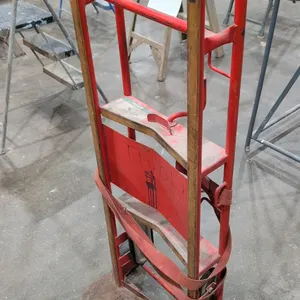 U-Haul heavy-duty metal appliance hand truck. Features a red-painted steel frame, integrated ratcheting cargo strap, stair-climber tracks, dual handle