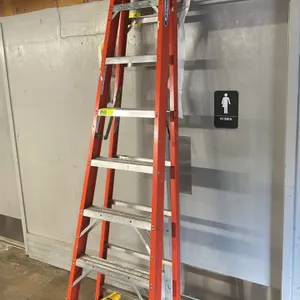 Werner 8' fiberglass step ladder. Features orange non-conductive fiberglass rails, seven aluminum rungs, a yellow plastic top cap with integrated tool