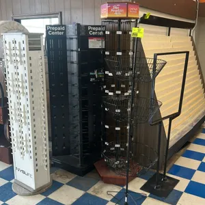 Assorted metal merchandisers and sign stand. Includes (1) white NYSLIFE rotating 4-sided eyewear display, (1) black 3-sided rotating Prepaid Center gi