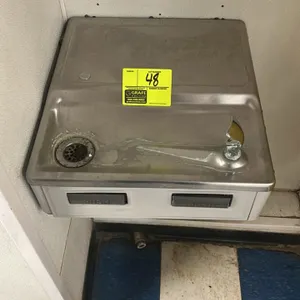 Halsey Taylor wall-mounted drinking fountain. Features a stainless steel basin with a single bubbler, dual front push-bar controls, and a gray metal c