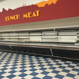 Tyler 44'L multi-tier open display case lineup. Composed of (3) 12' cases and (1) 8' case. Features solid adjustable shelving and black exterior with 